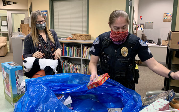 Staci Boehlke, left, helps Sergeant Holly Musser, from the Vancouver Police Activities League, unload Christmas presents for students. (Linda Jacobson)